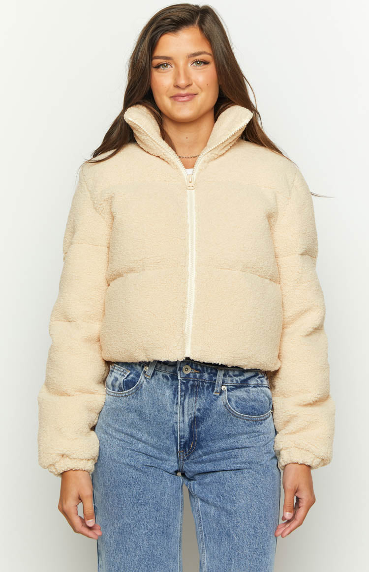 Rear view of a cream teddy puffer jacket, highlighting the textured fabric and high stand collar