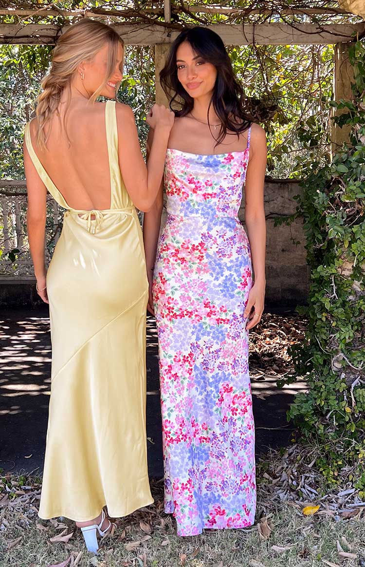Close-up of the yellow floral print satin cowl neck and defined waist seam of the dress