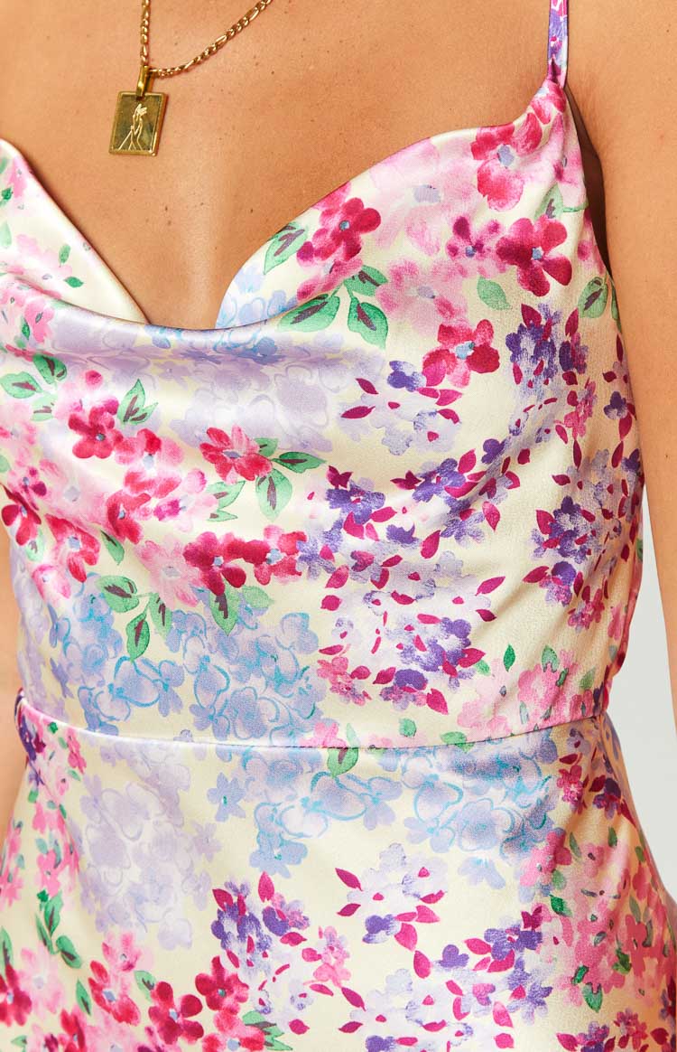 Vibrant pink, purple, and red floral print on a white fitted maxi dress with a cowl neck and spaghetti straps