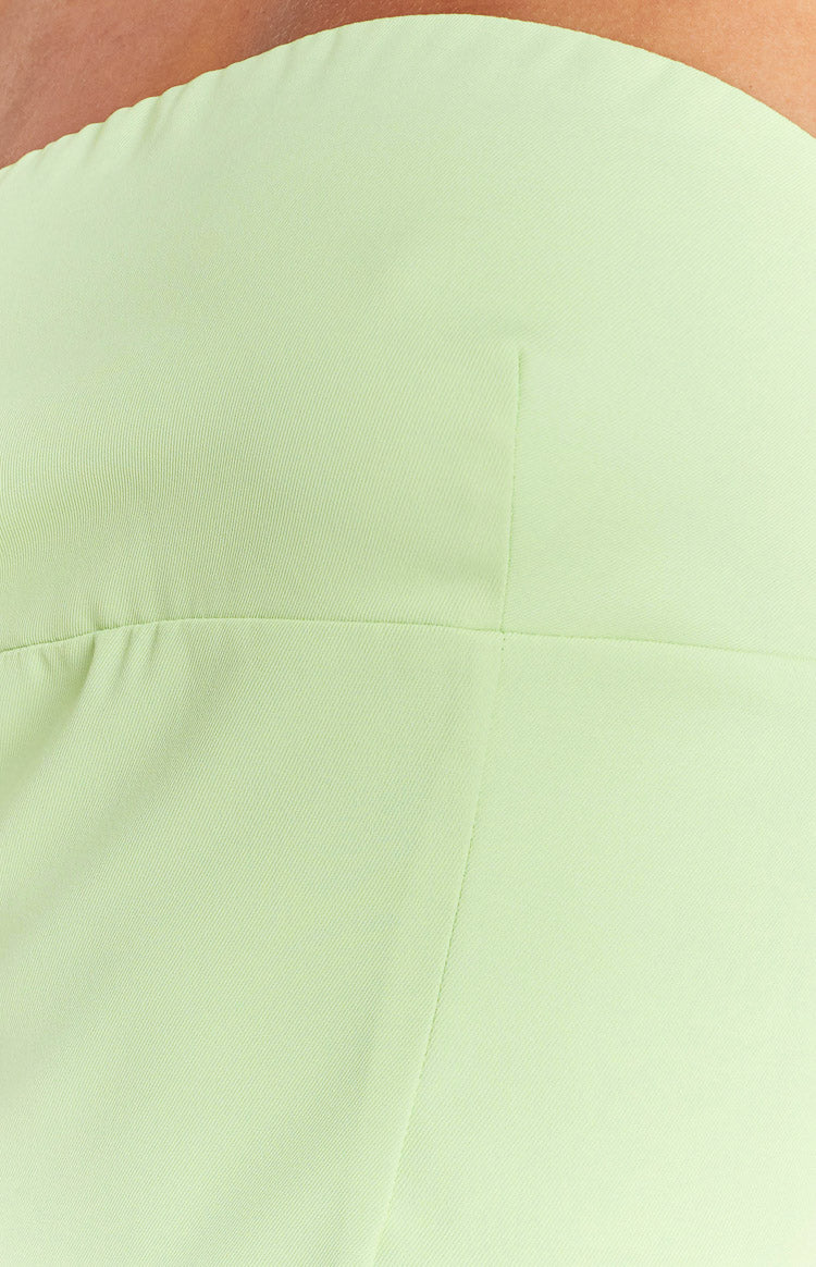 Close-up of the lime green mini dress fabric showing a horizontal seam, vertical seam, and subtle gathering