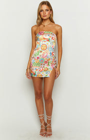 Front view of a vibrant eclectic print strapless mini dress with sun, moon, and floral motifs