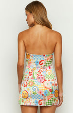 Back view of a strapless mini dress featuring a vibrant psychedelic print with suns, moons, and faces