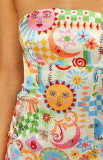 Close-up of the whimsical sun, moon, and floral print on the strapless bodice of the mini dress