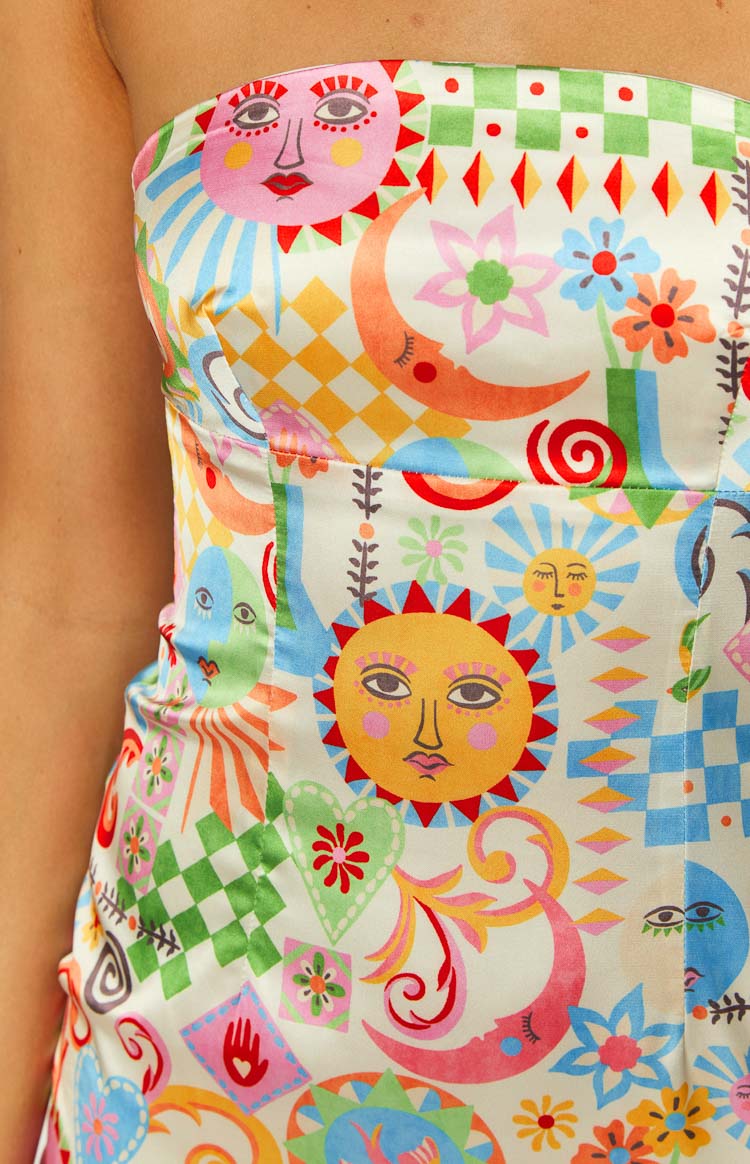 Close-up of the whimsical sun, moon, and floral print on the strapless bodice of the mini dress