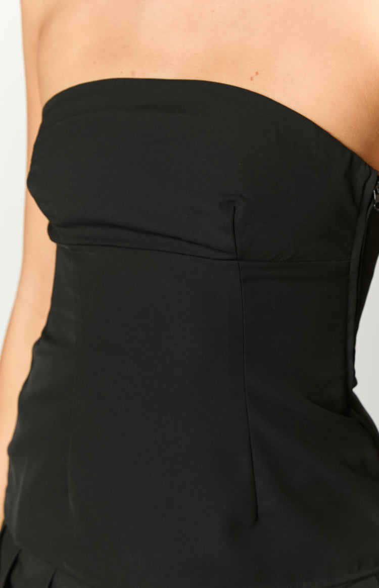 Rear view of a black strapless top showing the straight back and fitted bodice with a subtle peplum hem