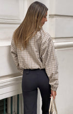 Rear view of a beige plaid funnel neck jacket with a relaxed fit and elasticated blouson hem
