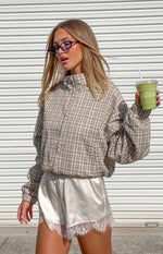 Beige plaid funnel neck jacket with a half-zip front, braided detail, voluminous sleeves, and blouson fit