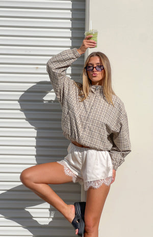 Beige plaid funnel neck jacket with half-zip, cropped elasticated hem, and ruffled front detail