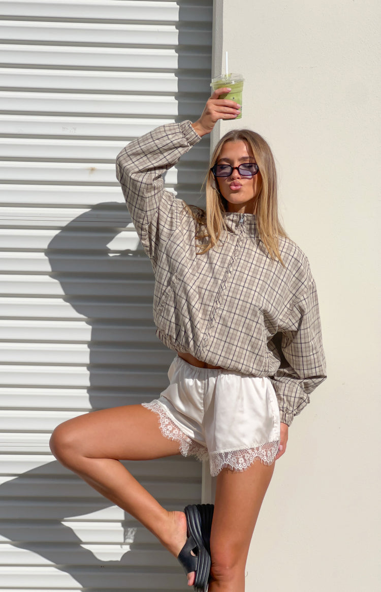 Beige plaid funnel neck jacket with half-zip, cropped elasticated hem, and ruffled front detail