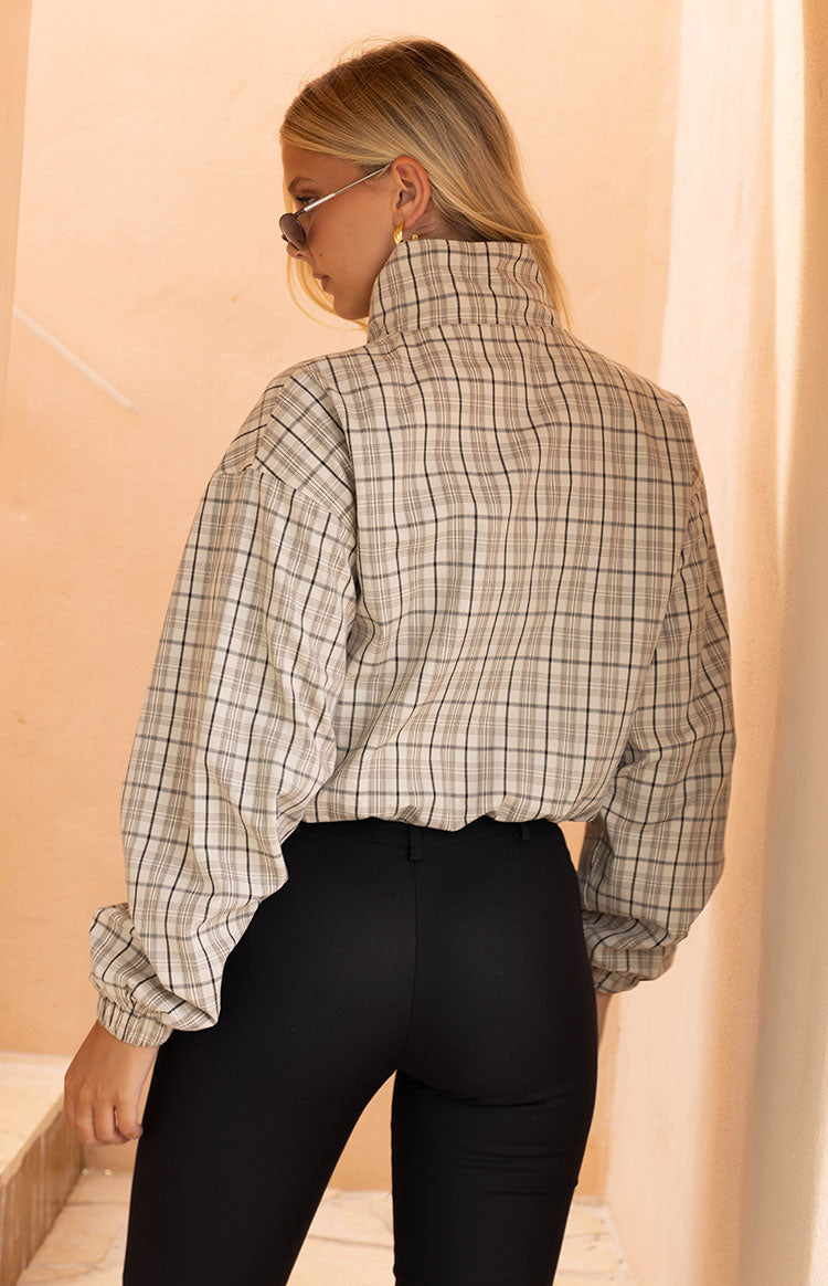 Front view of a beige plaid funnel neck jacket, partially unzipped, with elasticated cuffs and hem