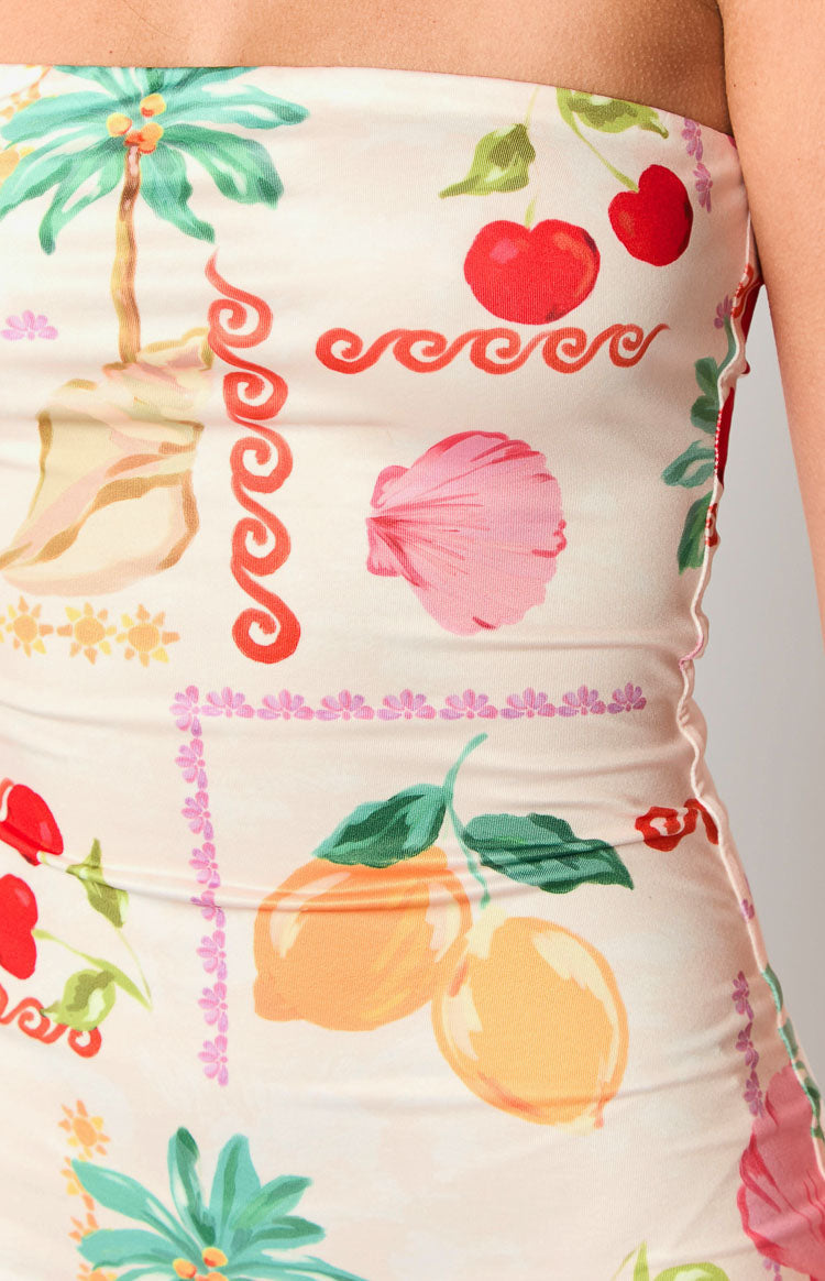 Close-up of the cream resort print fabric featuring palm trees cherries lemons and seashells with a ruffled side seam