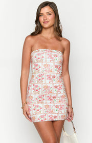 Front view of a white strapless mini dress with pink and orange paisley floral print and chain borders