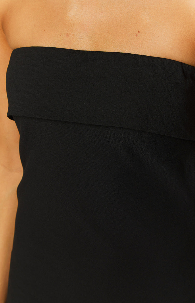 Back view of a black strapless maxi dress with an elasticated upper band and side waist cutouts