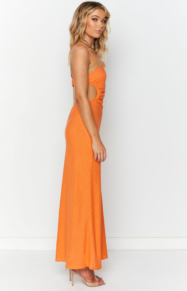 Side view of an orange maxi dress showing the waist cutouts with ruched detailing and thin spaghetti straps