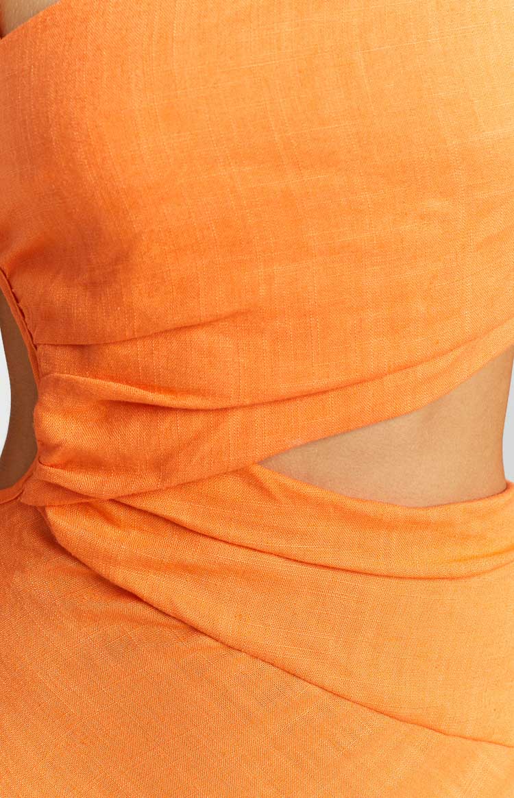 Close-up of the orange maxi dress showing the side cutouts and ruched waist detail with textured fabric