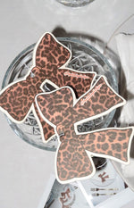 Several bow-shaped air fresheners in leopard print, featuring light pink and dark brown spots, arranged together