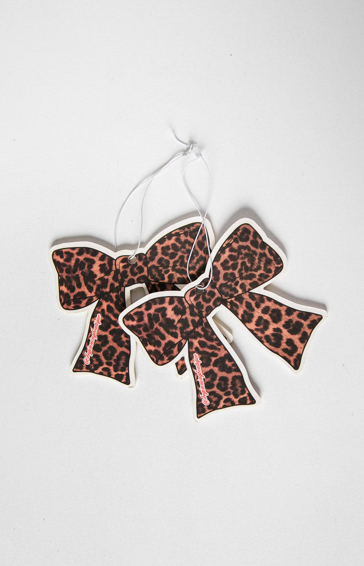 Two leopard print bow-shaped air fresheners, one slightly behind the other, with white hanging strings
