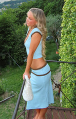 Side view of a light blue jersey top with deep V-neck, short cap sleeves, and brown contrast binding