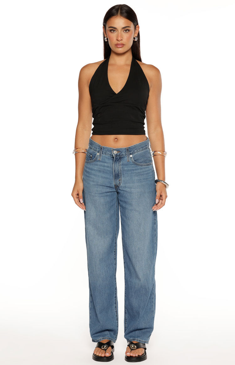 Front view of mid wash baggy dad jeans with a relaxed straight leg and classic five-pocket styling