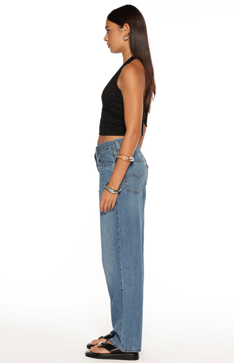 Side view of mid wash blue baggy dad jeans with a loose straight leg fit