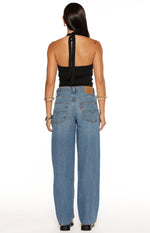 Rear view of mid wash baggy dad jeans with loose fit, back pockets, red tab, and leather patch