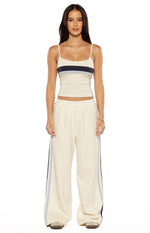Front view of a white fitted singlet with a scoop neckline and thin spaghetti straps, featuring navy and light blue horizontal stripes across the bust