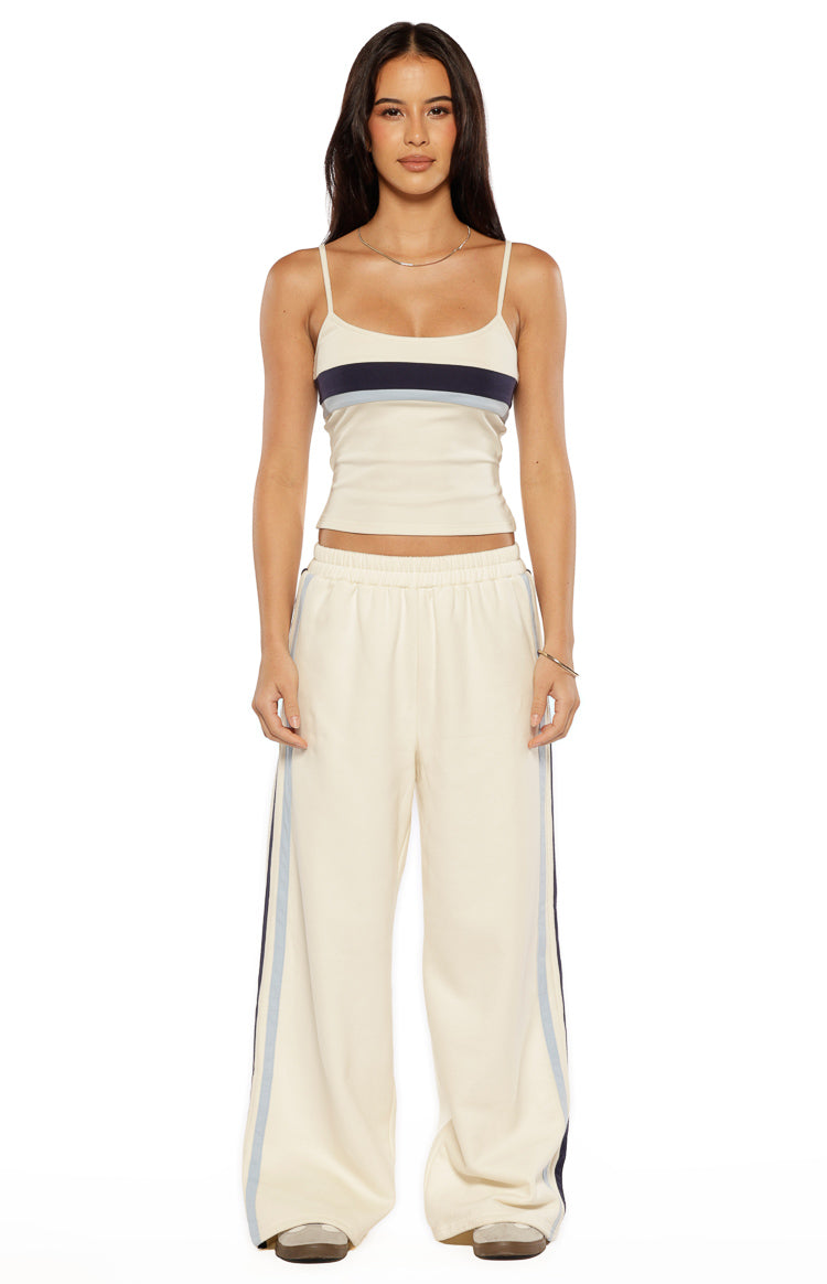 Front view of a white fitted singlet with a scoop neckline and thin spaghetti straps, featuring navy and light blue horizontal stripes across the bust