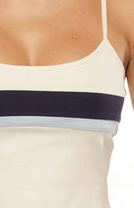 Close-up of the cream ribbed knit singlet showing the dark navy and light blue contrast stripes across the chest