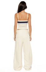 Rear view of white wide-leg pants with dark contrast side stripes and an elasticated waist