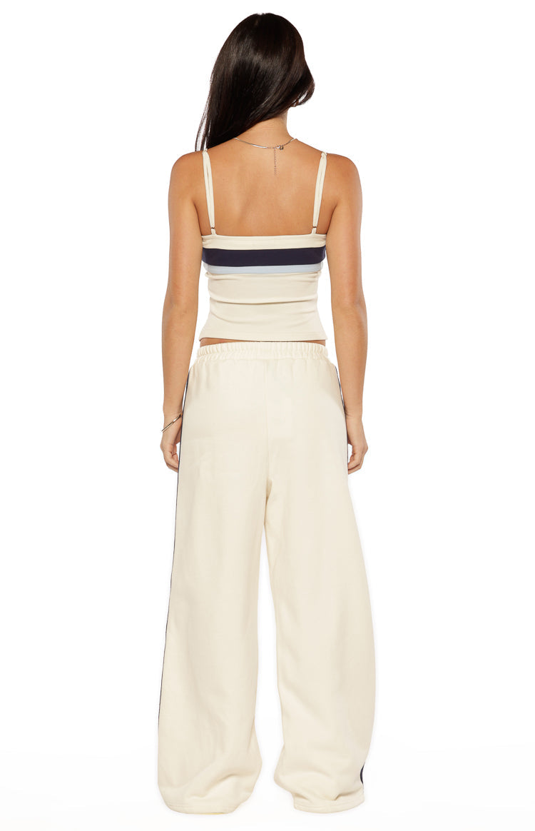 Rear view of white wide-leg pants with dark contrast side stripes and an elasticated waist