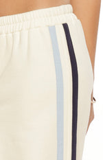 Close-up of the white pants showing the elasticated waistband and the light blue and navy side stripes