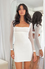 White bodycon mini dress with sheer mesh long sleeves, square neckline, and ruched bust