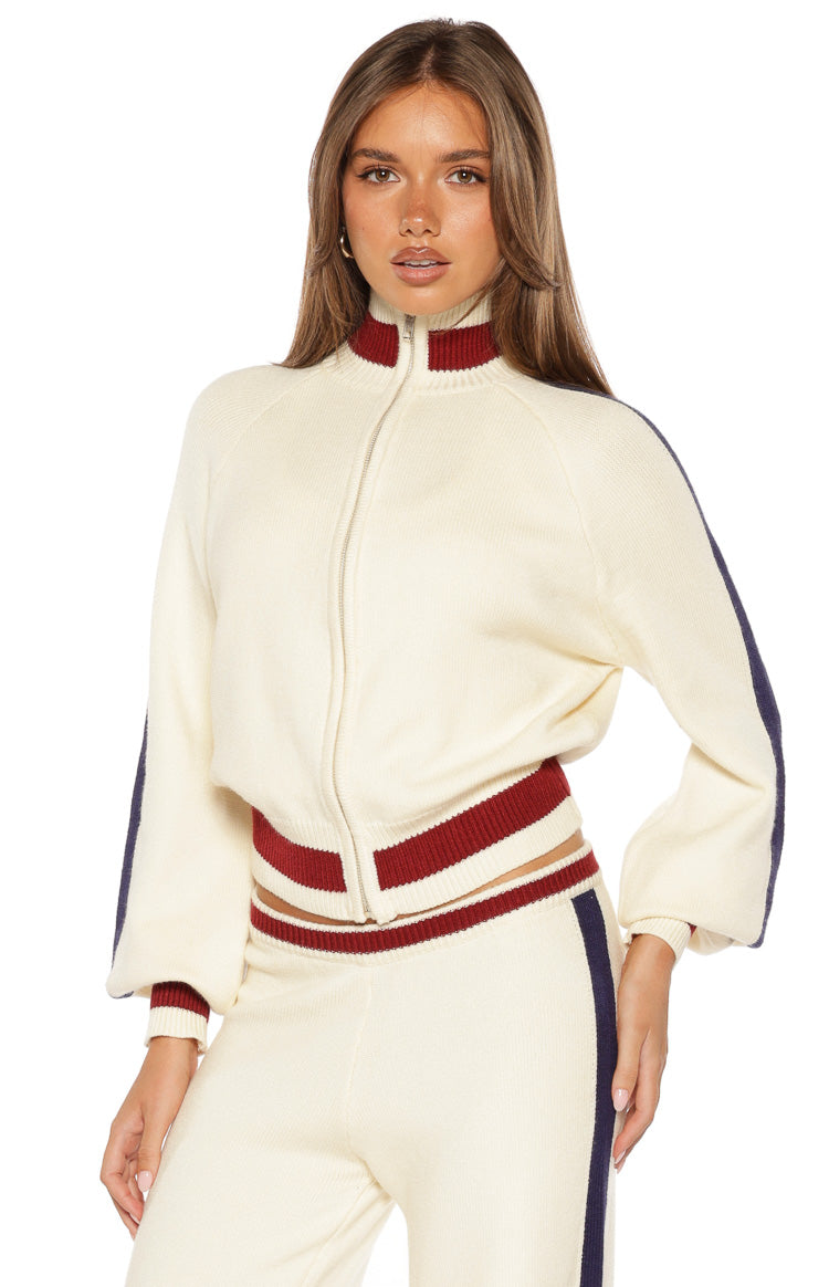 Cream knit zip sweater showing the high ribbed collar, full front zip, and cropped striped hem