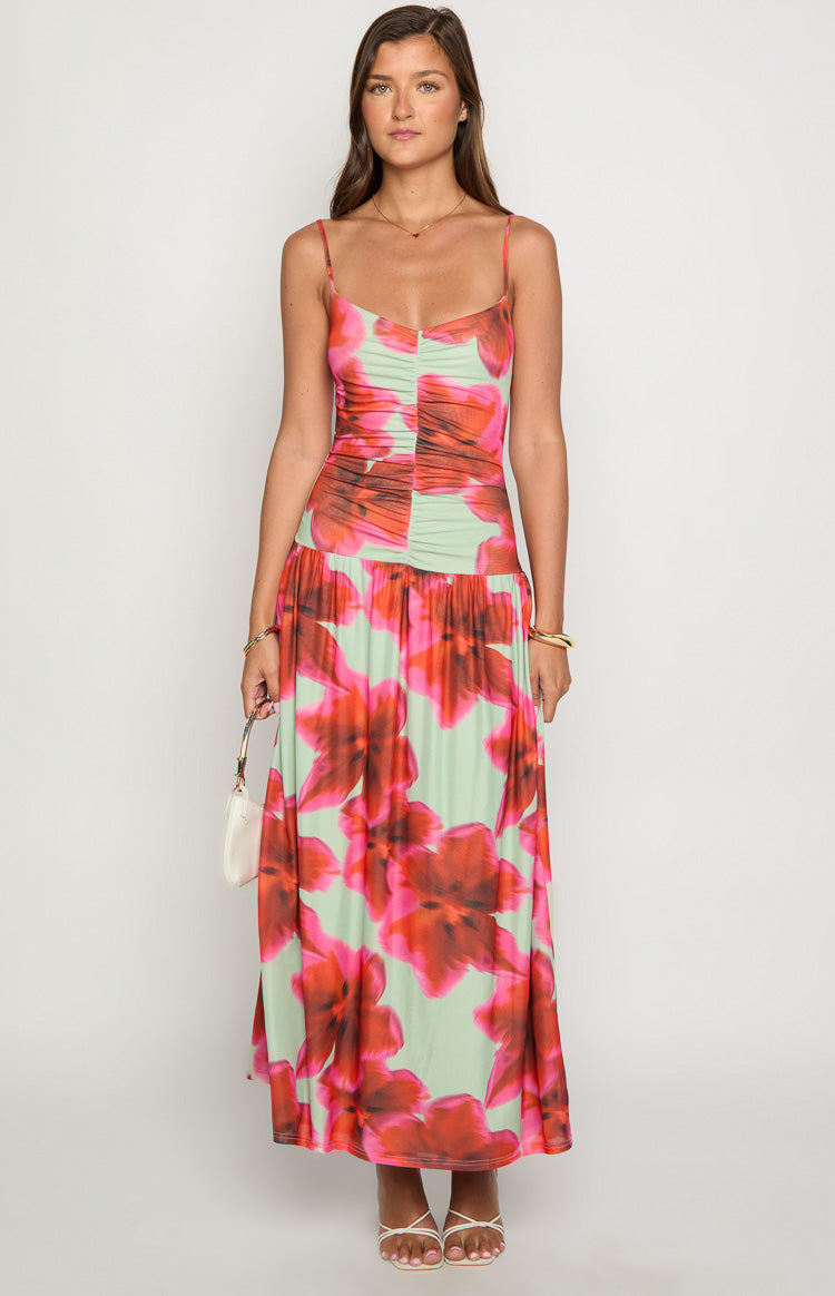 Front view of a green maxi dress with large red and pink floral print, ruched bodice and thin spaghetti straps