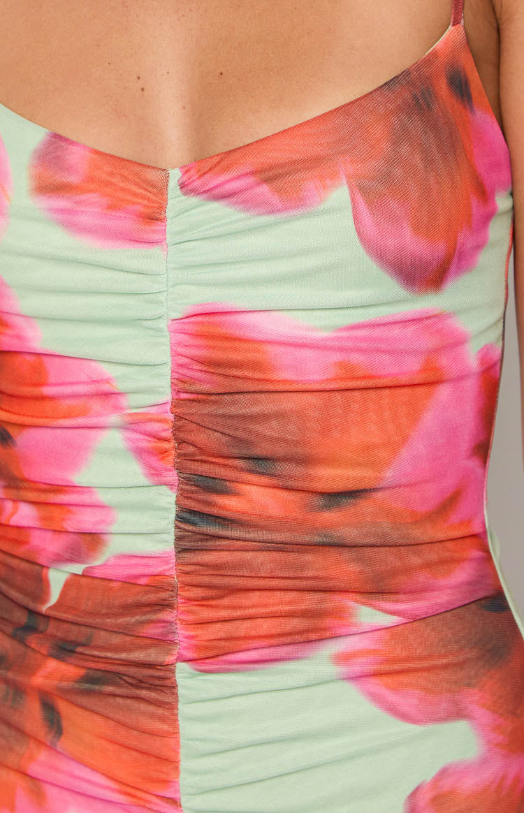 Ruched front bodice detail of a green floral print maxi dress with vibrant pink and orange flowers