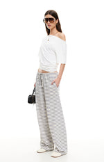 Side view of ash grey and white striped wide-leg pants with a drawstring waist and side pockets