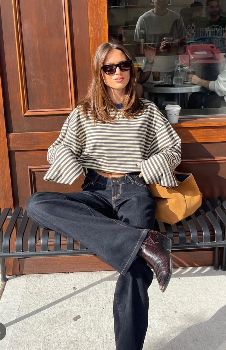 Front view of a cropped beige and black striped long sleeve top with wide sleeves