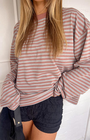 Oversized muted pastel pink and grey striped long sleeve top with relaxed fit and dropped shoulders