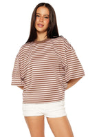 Woman in a brown and pink striped oversized cropped tee with white shorts a sweet and casual look for Spring