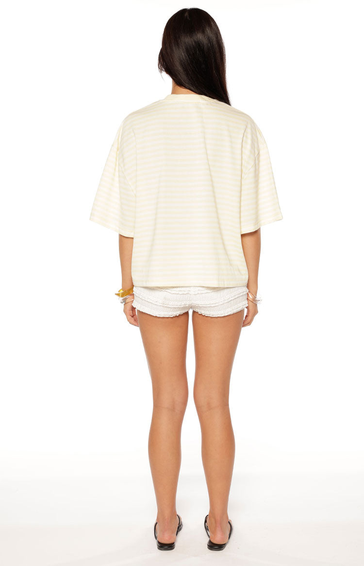 Rear view of a pale yellow and white striped short sleeve top with a relaxed, boxy fit and wide sleeves