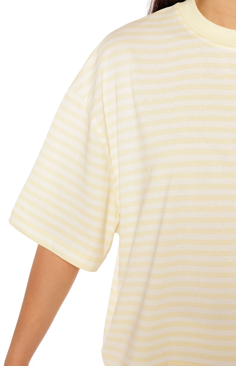 Close-up of the dropped shoulder seam and wide short sleeve of the light yellow and white striped top