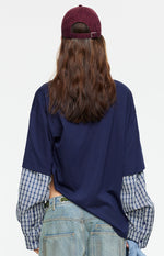 Rear view of the navy oversized shirt with blue and white plaid layered long sleeves