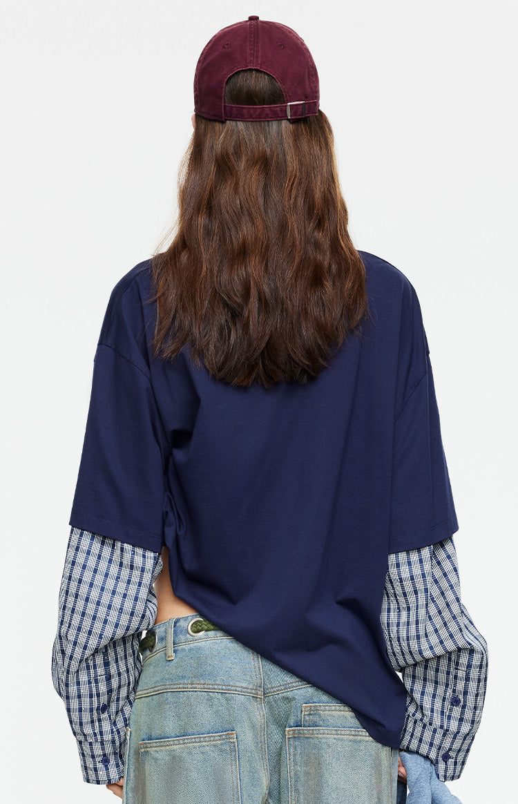 Rear view of the navy oversized shirt with blue and white plaid layered long sleeves