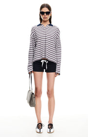 Front view of a grey and black stripe long sleeve jersey top with a navy polo collar and relaxed, slightly cropped fit