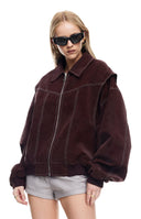 blonde model wearing an oversized chocolate brown textured bomber jacket with contrast stitch details