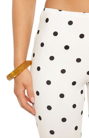 Close-up of the elasticated waistband and cream fabric with black polka dots on capri pants