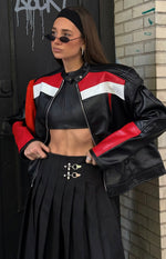 Close-up of the black faux leather biker jacket with red and white stripe details and a high snap-button collar