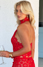 Side view of a red crochet halter top with a high choker neck and open back detail