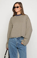 brunette model wearing a navy and beige striped long sleeve top paired with a light wash denim mini skort