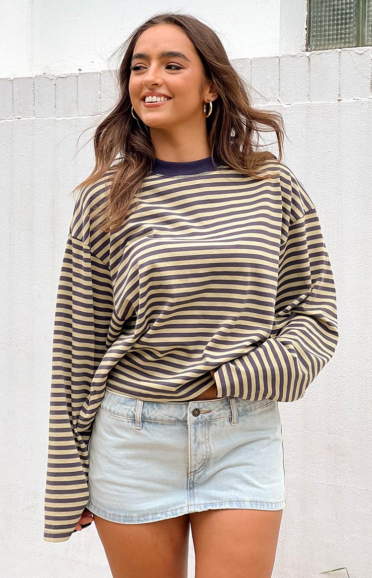 Side view of a beige and black striped long sleeve top with an oversized fit and voluminous sleeves